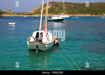 Unelegant Kraxeln an Bord eines Drascombe lugger, Porth Conger, St. Agnes, Isles of Scilly, UK, MODEL RELEASED Stockfoto