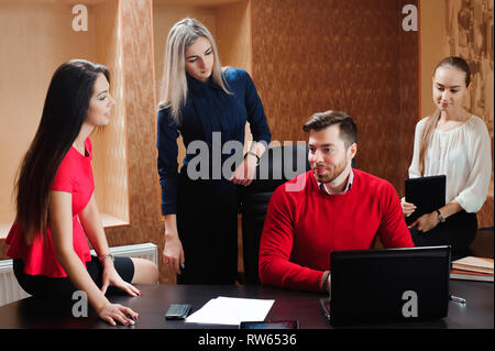 Gruppe von lächelnden inspiriert junge Geschäftsleute zusammen arbeiten im Büro. Stockfoto