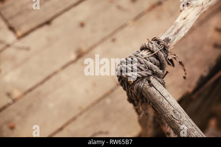 Retro Style Architektur, Holzzaun Struktur, Detailansicht auf Bindung der Seile. Stockfoto