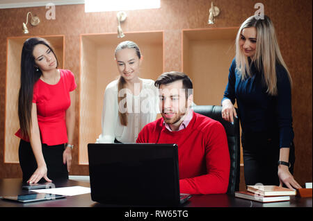 Gruppe von lächelnden inspiriert junge Geschäftsleute zusammen arbeiten im Büro. Stockfoto