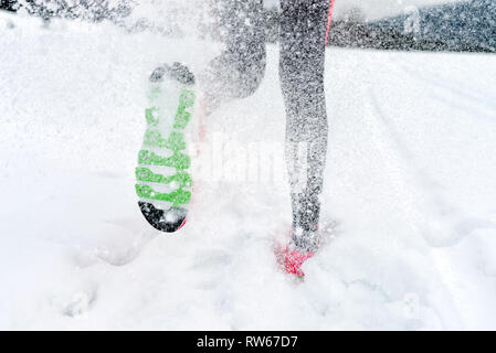 Teenager, die auf tiefen Schnee im Winter Berge. Fokus auf der Sohle des Schuhs - Läufer Joggen im Schnee Stockfoto