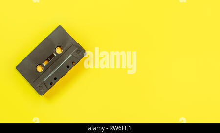 Von oben nach unten Aussicht, alt, Audio Tape in Kassette am gelben Brett, Platz für Text auf der rechten Seite. Stockfoto