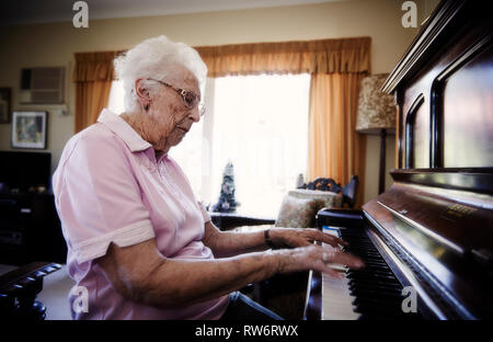 Die 96-jährige Jean McDougall Klavier spielt in ihrem Haus. Ihre schönen texturierte Hände fliegen über die Tasten des Klaviers. Stockfoto