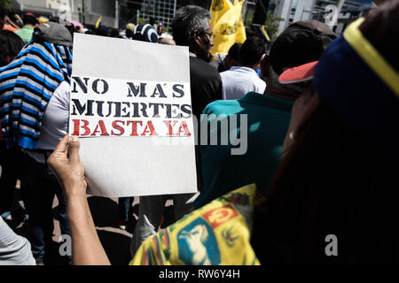 Eine Frau gesehen, die ein Plakat auf einer Kundgebung in Unterstützung von Juan Guaido. Juan Guaido, der venezolanischen Opposition, wo sich viele Nationen als legitime interim Präsident Venezuelas erkannt haben, grüßt seine Anhänger während einer Kundgebung gegen die Regierung von Präsident Nicolas Maduro in Caracas. Stockfoto