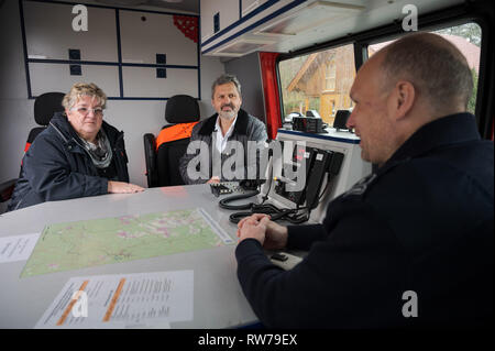 Mehlingen, Deutschland. 05 Mär, 2019. Monika Rettig (SPD, l-r), Bürgermeister von mehlingen und Andreas Ändern (SPD), Bürgermeister von Enkenbach-Alsenborn, sitzen zusammen mit Feuerwehrmann Heiko Becker in einem Notfall das Fahrzeug vor dem Haus der Toten Landschaft Gärtner, der einen Arzt mit einem booby Trap getötet vermutet wird. Credit: Oliver Dietze/dpa/Alamy leben Nachrichten Stockfoto