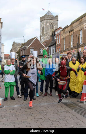 Salisbury, Wiltshire, UK. 5 Mär, 2019. Konkurrenten an den Start in den jährlichen Pfannkuchen Rennen an der High Street, Salisbury konkurrieren. Die Veranstaltung wird von St. Thomas Kirche und die trussell Trust organisiert. Stockfoto