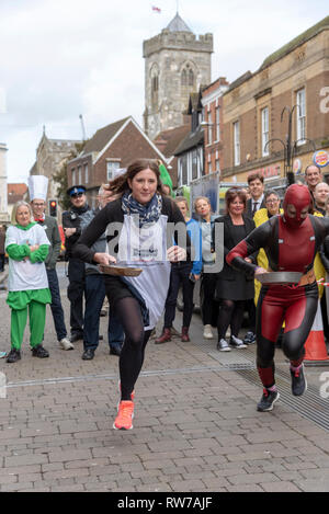 Salisbury, Wiltshire, UK. 5 Mär, 2019. Konkurrenten an den Start in den jährlichen Pfannkuchen Rennen an der High Street, Salisbury konkurrieren. Die Veranstaltung wird von St. Thomas Kirche und die trussell Trust organisiert. Stockfoto