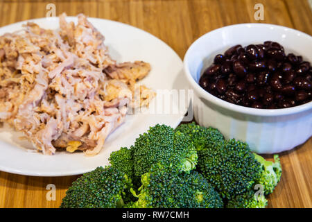 Brokkoli gekochtes Huhn und Schwarze Bohnen auf einem Holz Schneidebrett Stockfoto