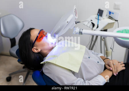 Laser Zahnaufhellung bei dantist Zimmer. Zähne, die für die Frau. Bleichen der Zähne beim Zahnarzt Klinik Stockfoto