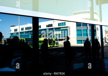 Blick auf Newport bus station inklusive Busse, Gebäude, und Passagiere, Newport, Isle of Wight, Großbritannien. Stockfoto