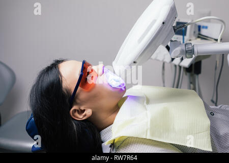 Laser Zahnaufhellung bei dantist Zimmer. Zähne, die für die Frau. Bleichen der Zähne beim Zahnarzt Klinik Stockfoto