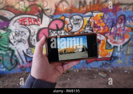 Ein Blick auf die Außenseite der Ruinen von Casa Grande wie auf einem iPhone gesehen, während Sie in den Graffiti gefüllte Höhlen. Stockfoto