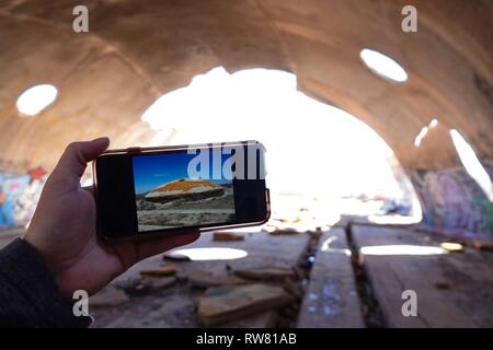 Ein Blick auf die Außenseite der Ruinen von Casa Grande wie auf einem iPhone gesehen, während Sie in den Graffiti gefüllte Höhlen. Stockfoto