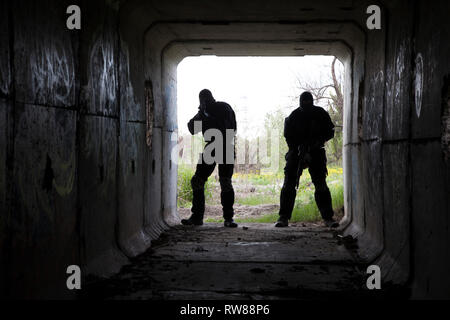 Silhouette von Special Forces Betreiber mit Waffen in den Tunnel. Stockfoto