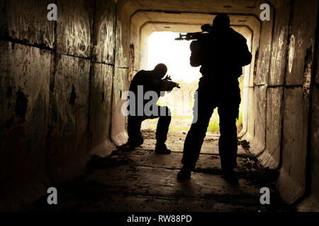 Silhouette von Special Forces Betreiber mit Waffen in den Tunnel. Stockfoto