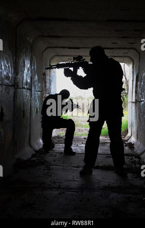 Silhouette von Special Forces Betreiber mit Waffen in den Tunnel. Stockfoto