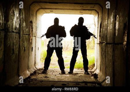 Silhouette von Special Forces Betreiber mit Waffen in den Tunnel. Stockfoto