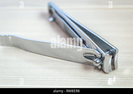 Nail cutter nail Fräser Nagelformer gehalten auf einer hölzernen Tisch. Kopieren Sie Speicherplatz zur Verfügung Stockfoto