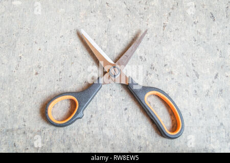 Blick von oben auf eine Schere auf einer strukturierten braun Tabelle gehalten. Platz für Text. Kopieren Sie Raum zur Verfügung gestellt. Stockfoto