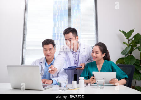 Gruppe von Ärzten und Krankenschwestern die Prüfung Ärztlicher Bericht des Patienten. Ärzte gemeinsam mit dem Patienten am Krankenhaus. Stockfoto