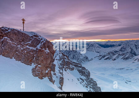 Tagesanbruch auf der Zugspitze Gipfel mit Gipfelkreuz Stockfoto