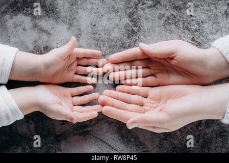 Nahaufnahme der Familie halten sich an den Händen, liebevolle fürsorgliche Mutter, Kind. Helfende Hand und hoffen, Konzept und Internationalen Tag des Friedens Stockfoto