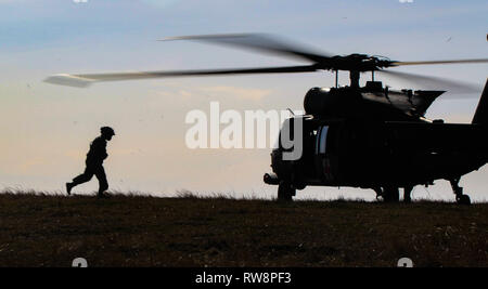 Die US-Armee Soldaten mit 3 Assault Helicopter Bataillon, 1 Aviation Regiment, 1 Combat Aviation Brigade, 1 Infanterie Division, läuft zu seinem Hubschrauber während eines kombinierten Air Assault Übung am Babadag Training Area, Rumänien, 28.02.2019. 3-1 AHB fing vor kurzem eine Rotation in Rumänien Atlantic beheben, einen gemeinsamen NATO-Engagement Bereitschaft zu errichten und die Verbindung zwischen den Verbündeten und Partner Nationen durch multinationale Ausbildung verbessert zu unterstützen. (U.S. Armee Foto von SPC. William Dickinson) Stockfoto