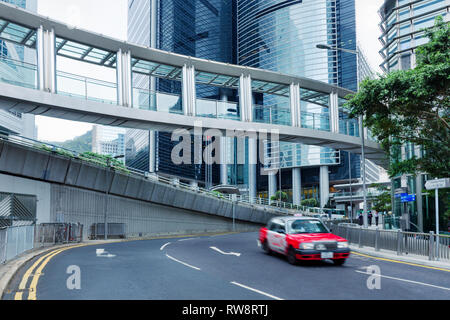 Straße der Innenstadt am Tag in China. Hong Kong City Central Street im westlichen Bezirk. Verschwommen Taxi Auto unterwegs Auf der Straße. Stadt Struktur. Stockfoto