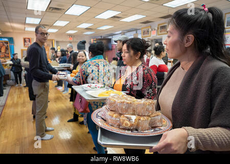 Anbeter in einem buddhistischen Tempel Form einer Montagelinie Lieferung von Nahrung vorbereitet und für ihre Mönche gekocht. In Elmhurst, Queens, New York Stockfoto