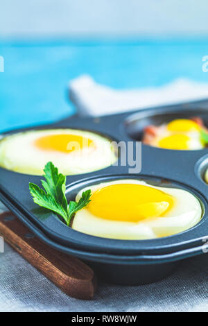Gebackene Eier in Backformen. Portioniert Auflauf aus sowbelly Speck und Eier im italienischen Stil. Stockfoto