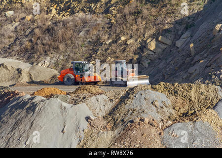 Walze Rüttelplatte und Planierraupe in steinigen Hang Ambiente Stockfoto