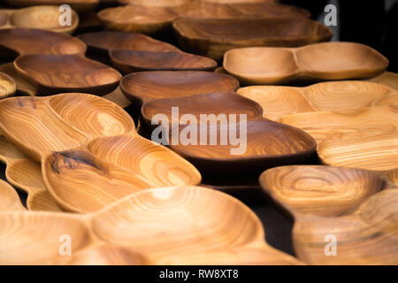 In der Nähe von Holz- Utensilien für die Küche, Schalen, Teller auf dunklem Hintergrund. Konzept der natürlichen Gerichten, einen gesunden Lebensstil. Textur aus Holz. Holz- Stockfoto