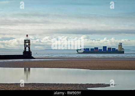 Ein frachtschiff vorbei an der Rundumleuchte an Crosby Strand, auf dem Weg nach Liverpool Docks Stockfoto