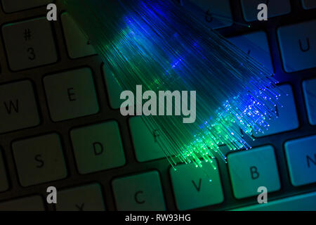 Bunte Glasfaser leuchten auf der Tastatur. High speed Internet Konzept. Datenübertragung Optic Fiber Kabel. Bündel viele optische Fasern, glühende di Stockfoto