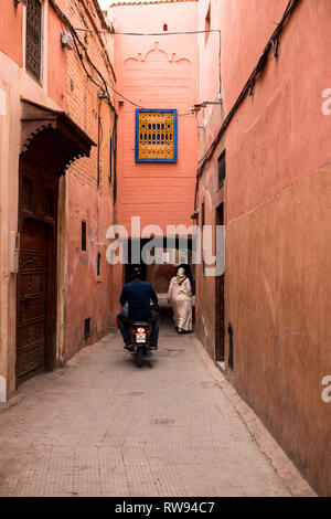 Typisch marokkanischen Gasse in den Souks der Medina von Marrakesch mit rot bemalten Häuser und einen kleinen Gehweg (Marrakesch, Marokko, Afrika) Stockfoto