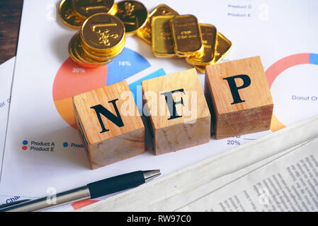 Text "Nfp" auf Holz Würfel mit Gold Bar und die Zeitung auf dem Tisch, wirtschaftliche Daten Konzept Stockfoto