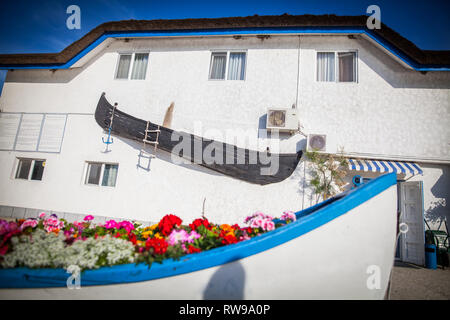 Eine alte verlassene Holz- Boot auf einer Wand angezeigt. Stockfoto