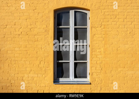Fenster auf gelb gestrichenen Wand Stockfoto