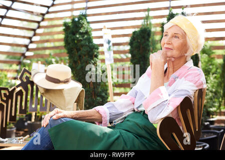 Nachdenklich Senior Frau Ruhe im Garten Stockfoto