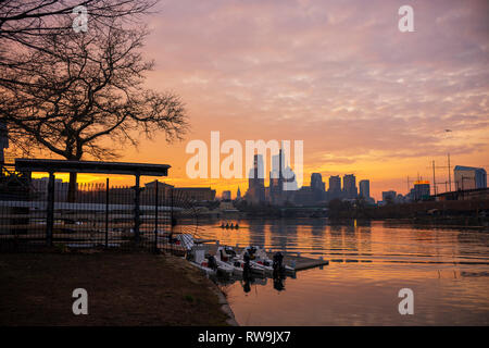 Eine Mannschaft Mannschaft Praktiken entlang der Schuylkill River bei Boathouse Row in der Nähe von Stadtzentrum Philadelphia bei Sonnenaufgang. Stockfoto