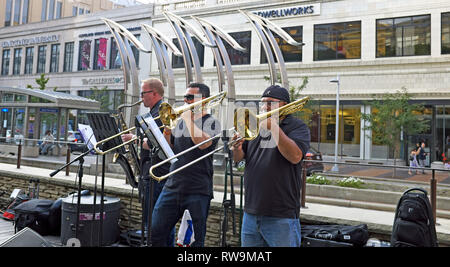 Am 14. August 2018 spielen drei Männer auf verschiedenen Horninstrumenten auf der US Bank Plaza im Cleveland Playhouse Square Theater District in Cleveland. Stockfoto