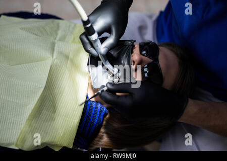 Eine latex-Platte, die den Zahn vom Rest der Mundhöhle während der Bestrahlung zu behandeln, zu isolieren. Bereiten Zahnärzte Zahn ein Meer zu installieren. Stockfoto