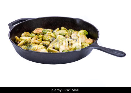 Gebratene organische Rosenkohl in einem Cast-Iron Skillet isoliert auf weißem Hintergrund. Stockfoto