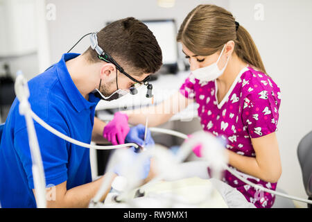 Männliche Zahnarzt mit Assistant Prüfung Mädchen Zähne in den Zahnarztstuhl Stockfoto