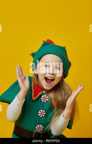 Fröhliches kleines Mädchen in einem Karneval Kostüm mit schönen blonden Haar über einen gelben Hintergrund. Kinder- Stil Stockfoto