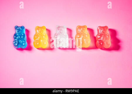 Eine Nahaufnahme von fünf bunten Gummibärchen, auf einem rosa Hintergrund mit Mohn studio Licht fotografiert. Stockfoto