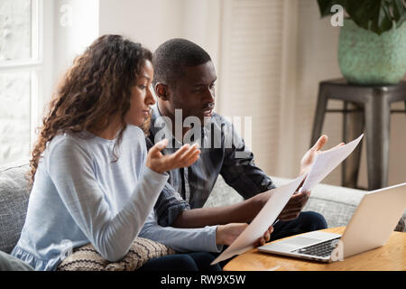 Betroffenen schwarz Paar lesen Rechnungen Schreibarbeit zu Hause in Betracht Stockfoto