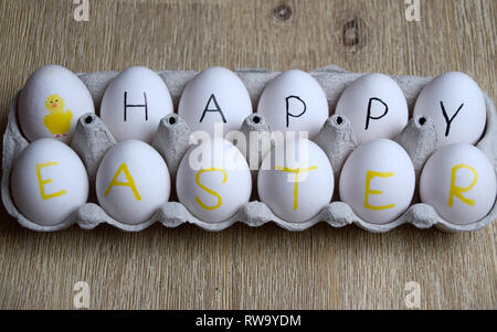 Frohe Ostern Gruß weiße Eier in einer Box auf hölzernen Hintergrund Stockfoto