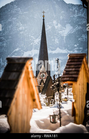 Der Turm der Evangelischen Kirche in Hallstatt mit schneebedeckten Berge in der Ferne Stockfoto