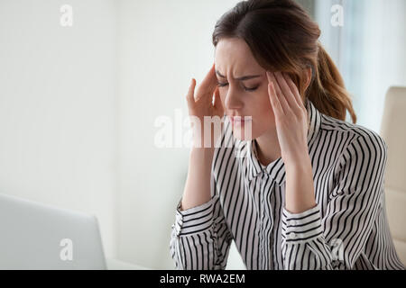 Müde hob Geschäftsfrau Gefühl starken Kopfschmerzen Tempel Massage im Büro Stockfoto